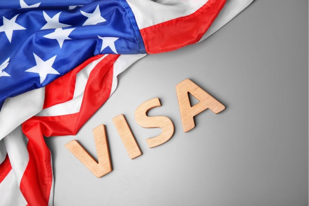 A close-up of a visa with the USA flag in the background, representing the connection between travel and American opportunities.